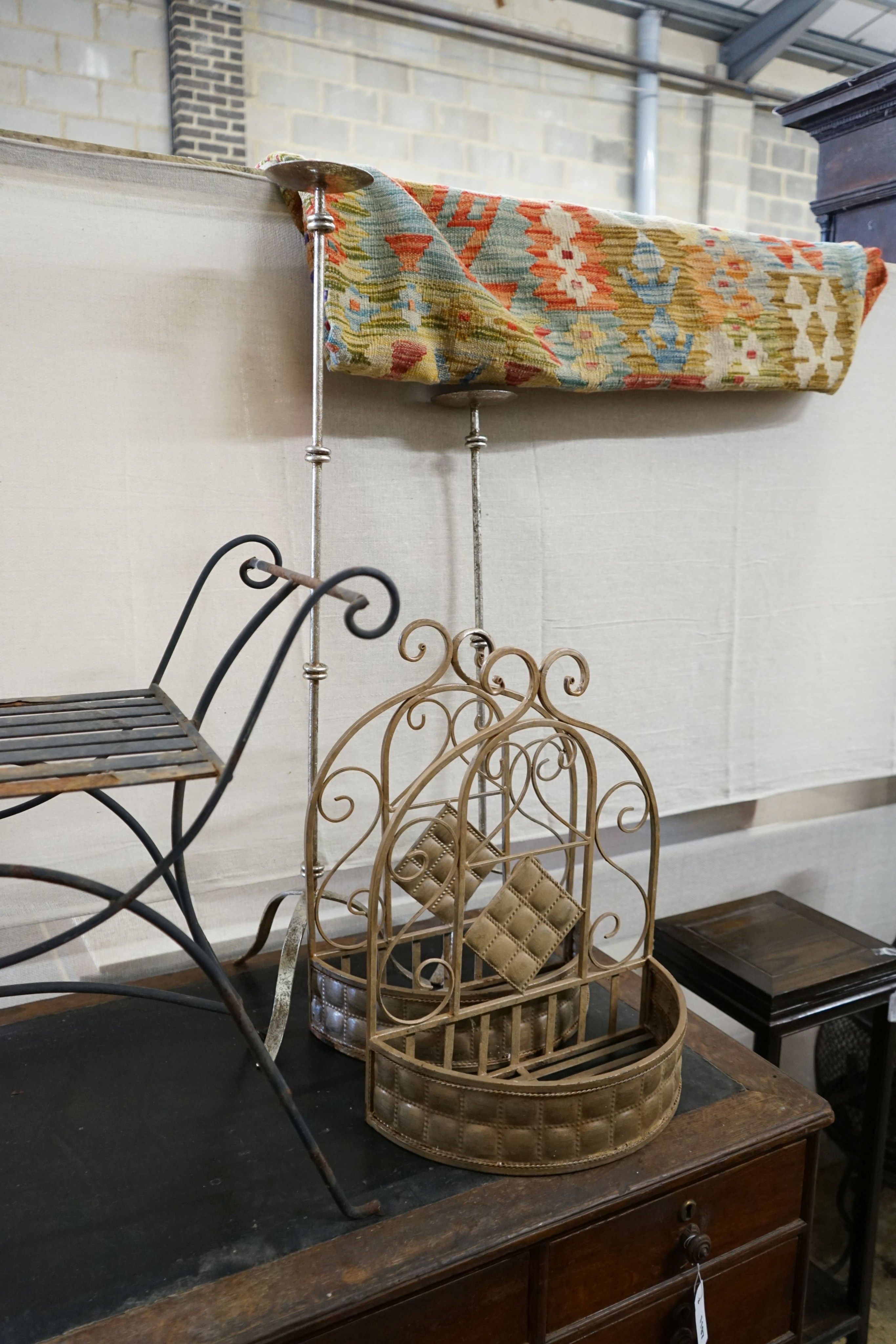 A wrought iron X framed stool, a pair of hanging planters and two large candle holders